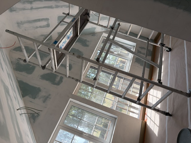 Opgebouwde rolsteiger, klaar voor schilderwerk aan een hoog plafond