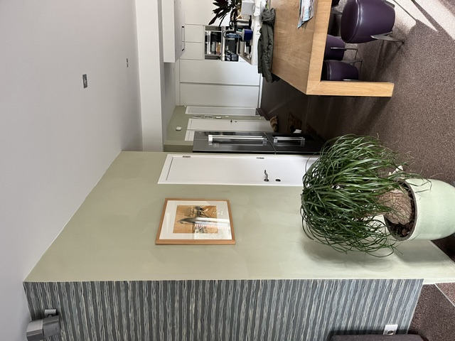 Afgewerkt interieur met sierlijke wandbekleding en open zicht op de keuken